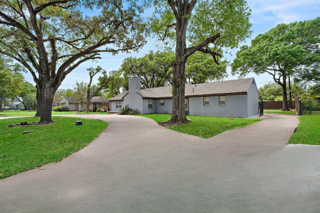 a view of a house with a big yard and large tree