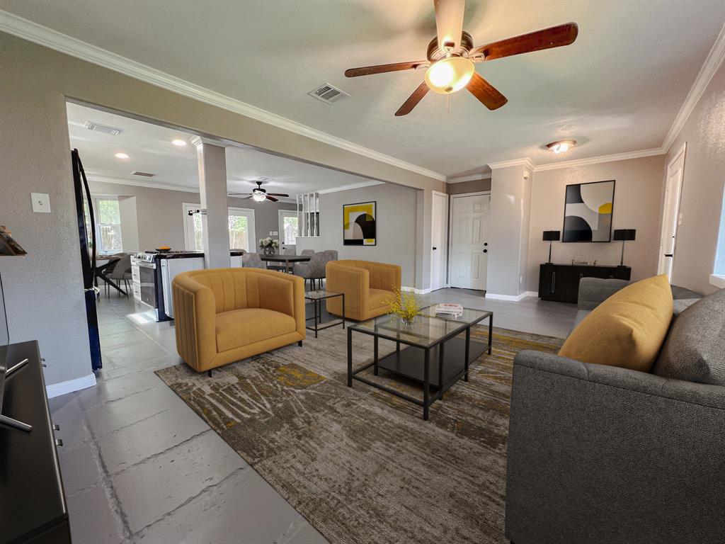 a living room with furniture kitchen view and a chandelier