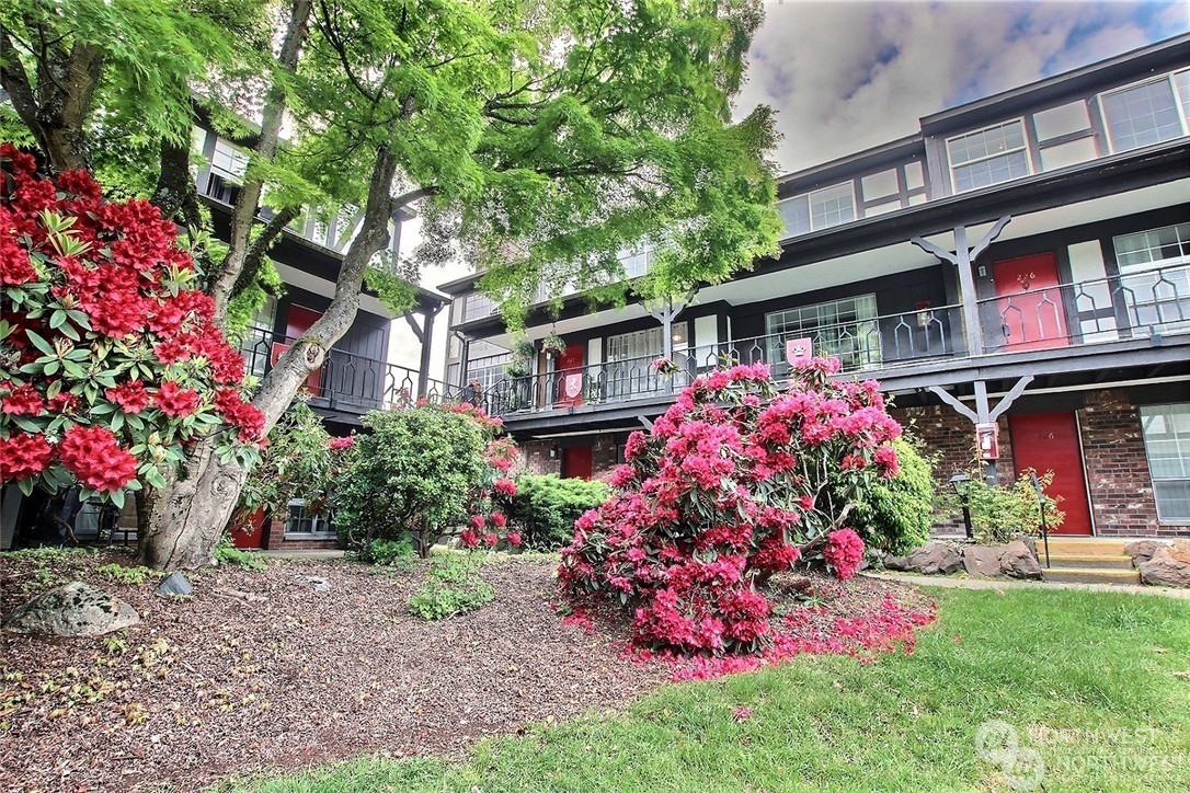 a front view of multi story residential apartment building with yard