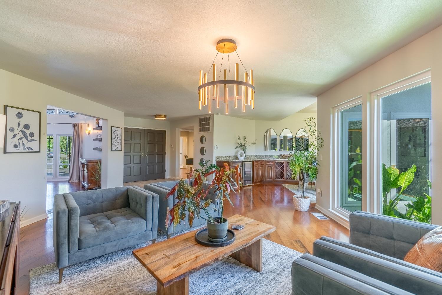 a living room with furniture a chandelier and a large window