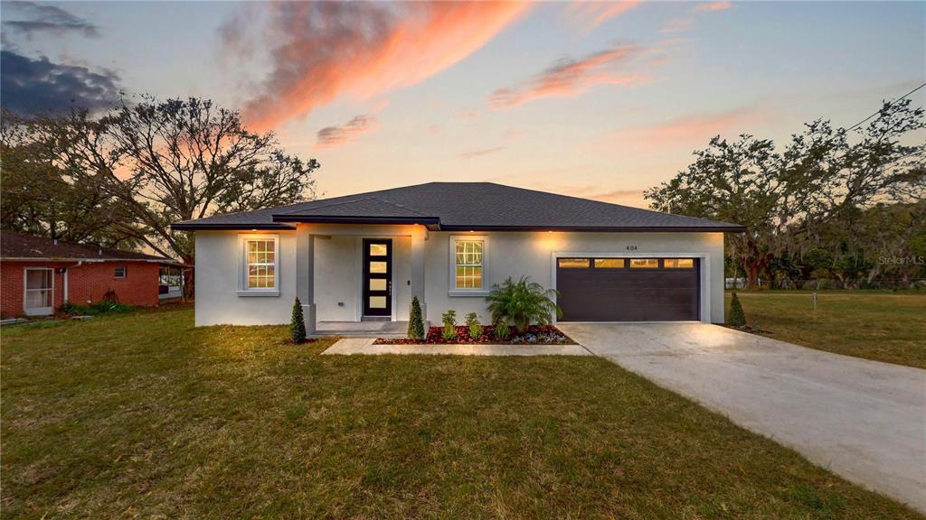 a front view of a house with a yard and garage