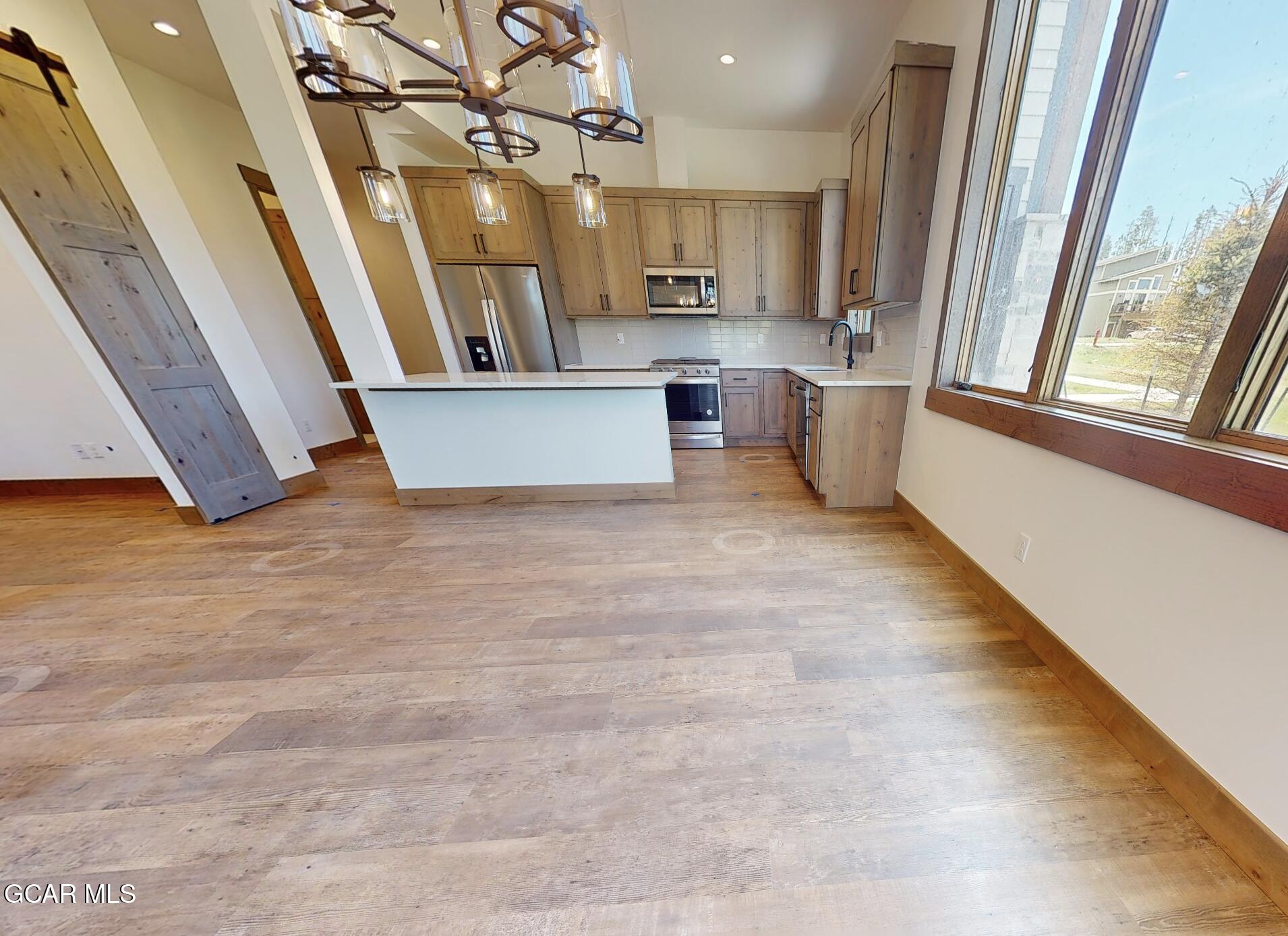 a view of a kitchen with a sink and dishwasher wooden floor