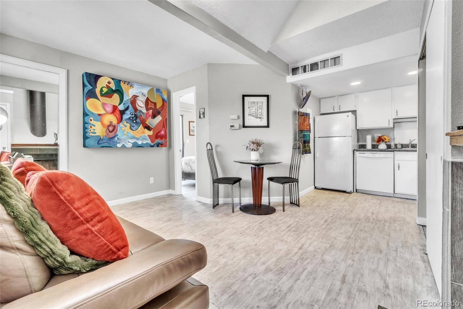 a living room with furniture and a refrigerator