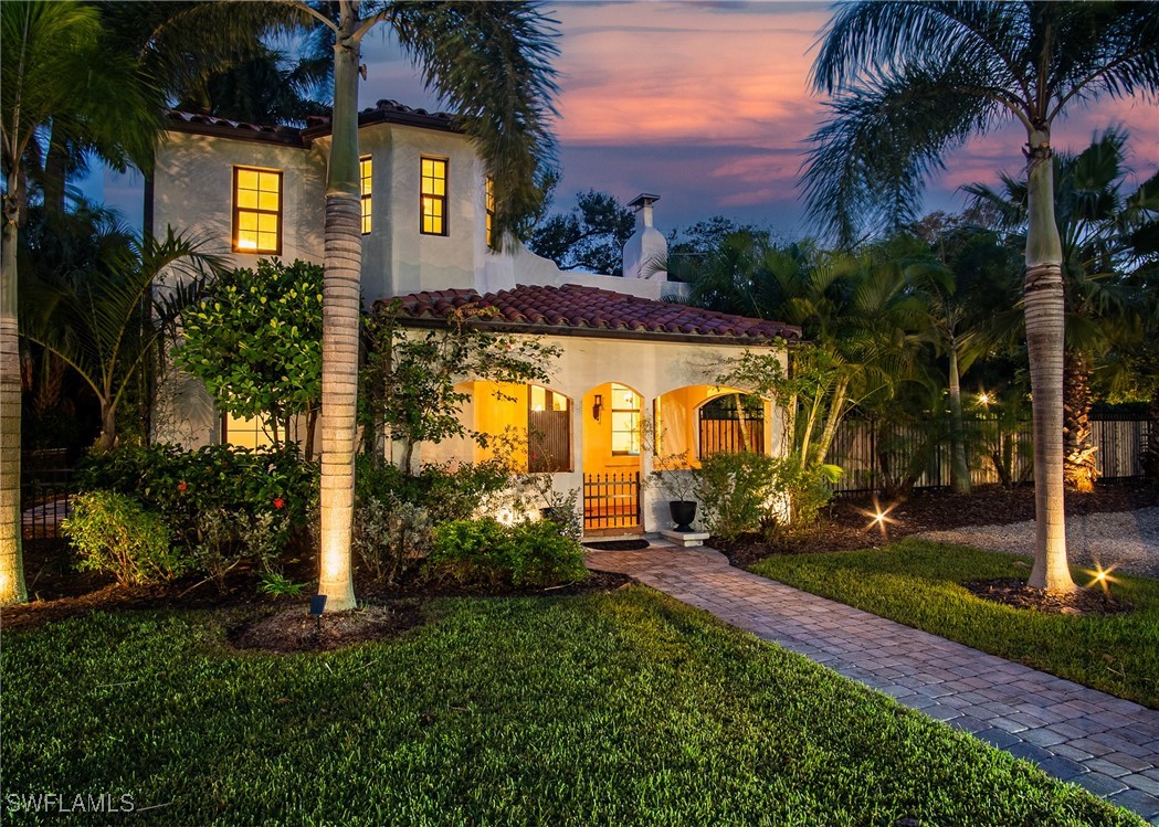 front view of house with a yard and potted plants