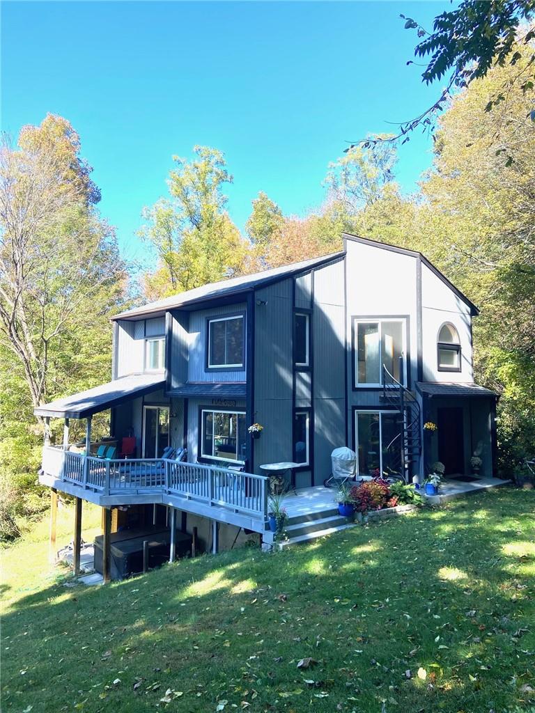 Front of house featuring a yard and a wooden deck