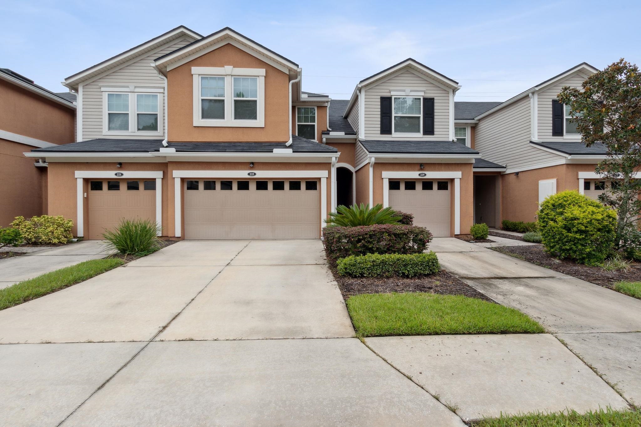 a front view of a house with a yard and garage