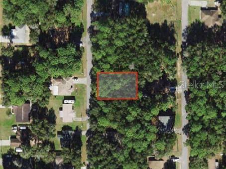 an aerial view of residential house with outdoor space and trees all around