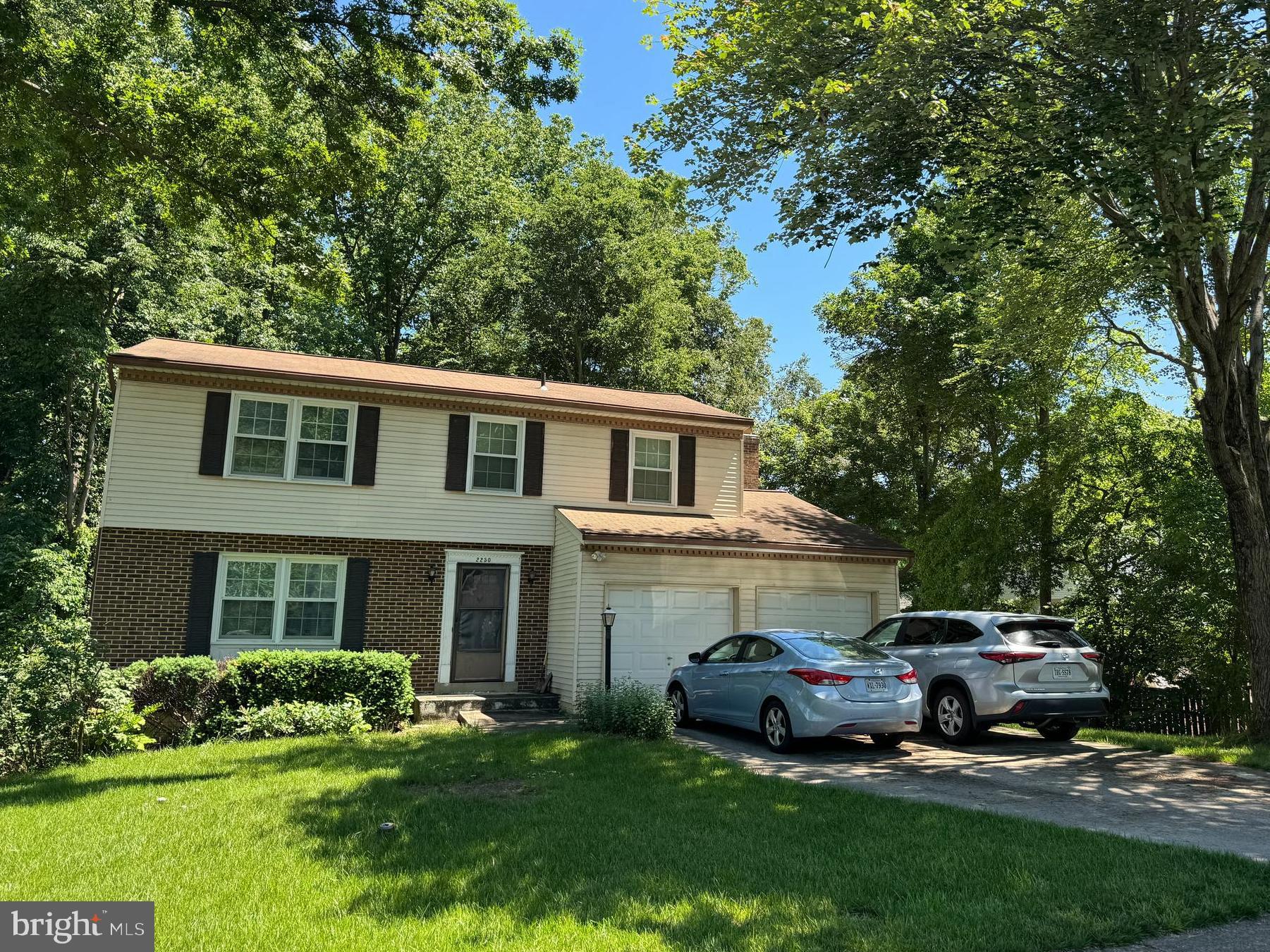 a front view of a house with a garden and trees