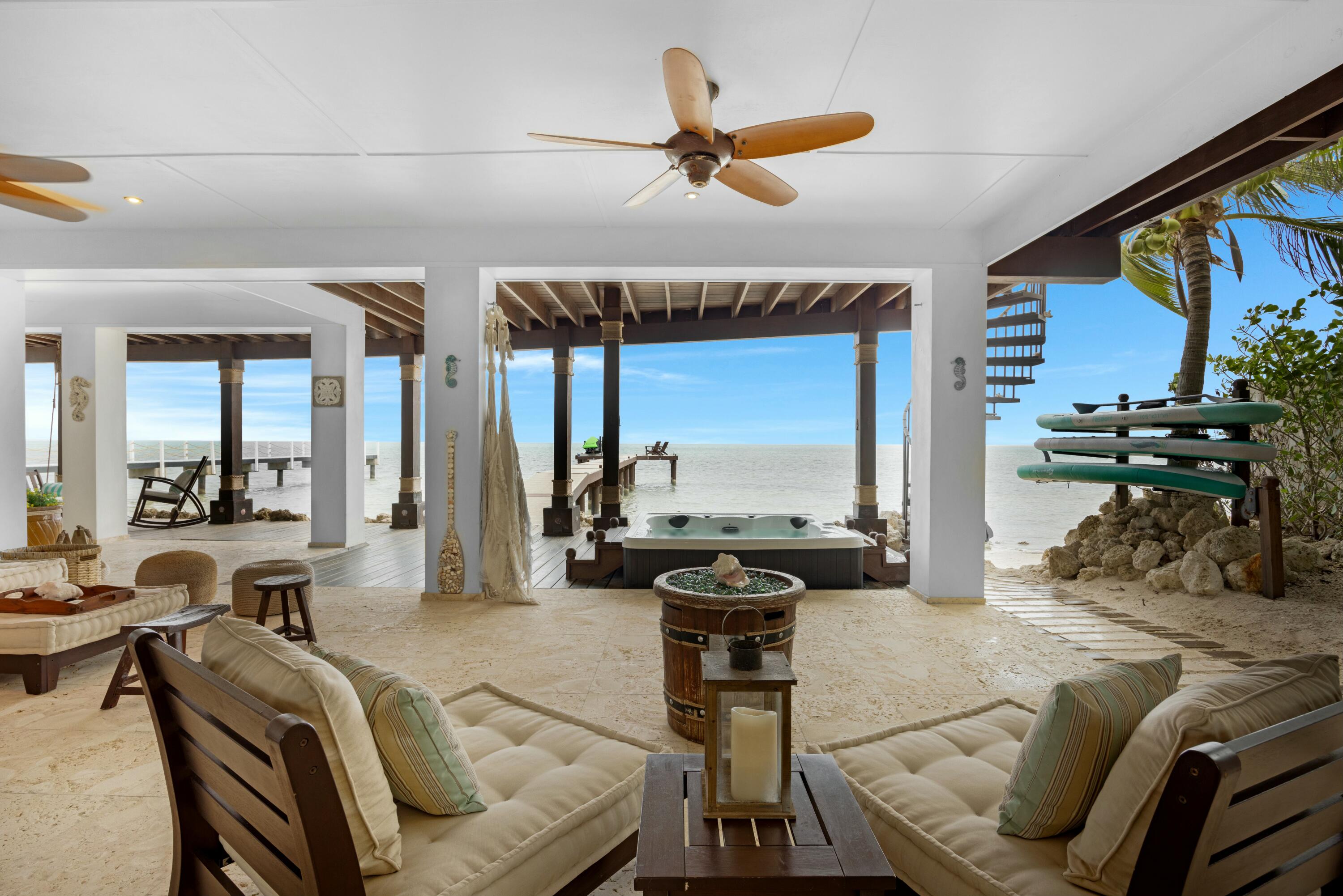 a living room with furniture a rug kitchen view and a large window