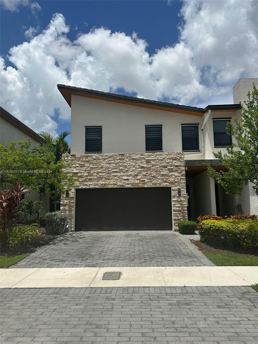 a front view of a house with a garden