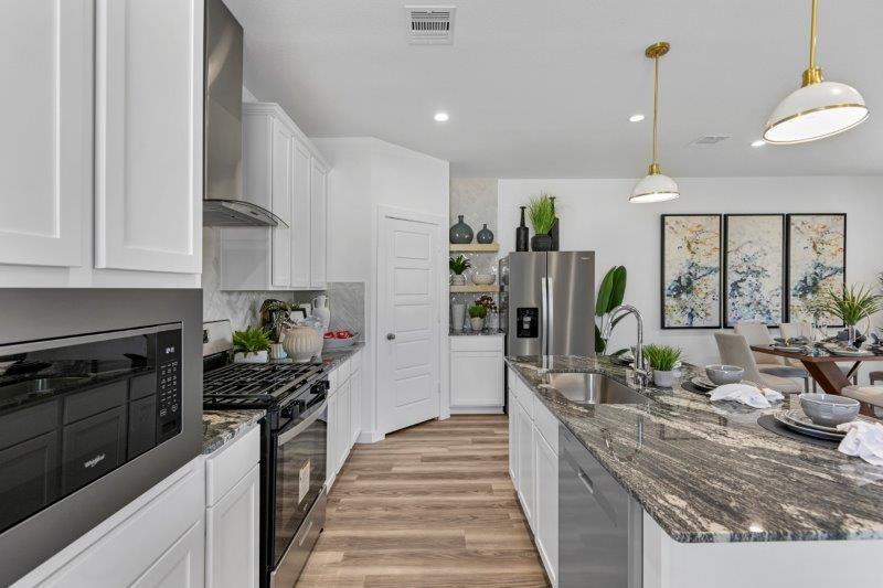 a kitchen with kitchen island granite countertop lots of counter top space and stainless steel appliances