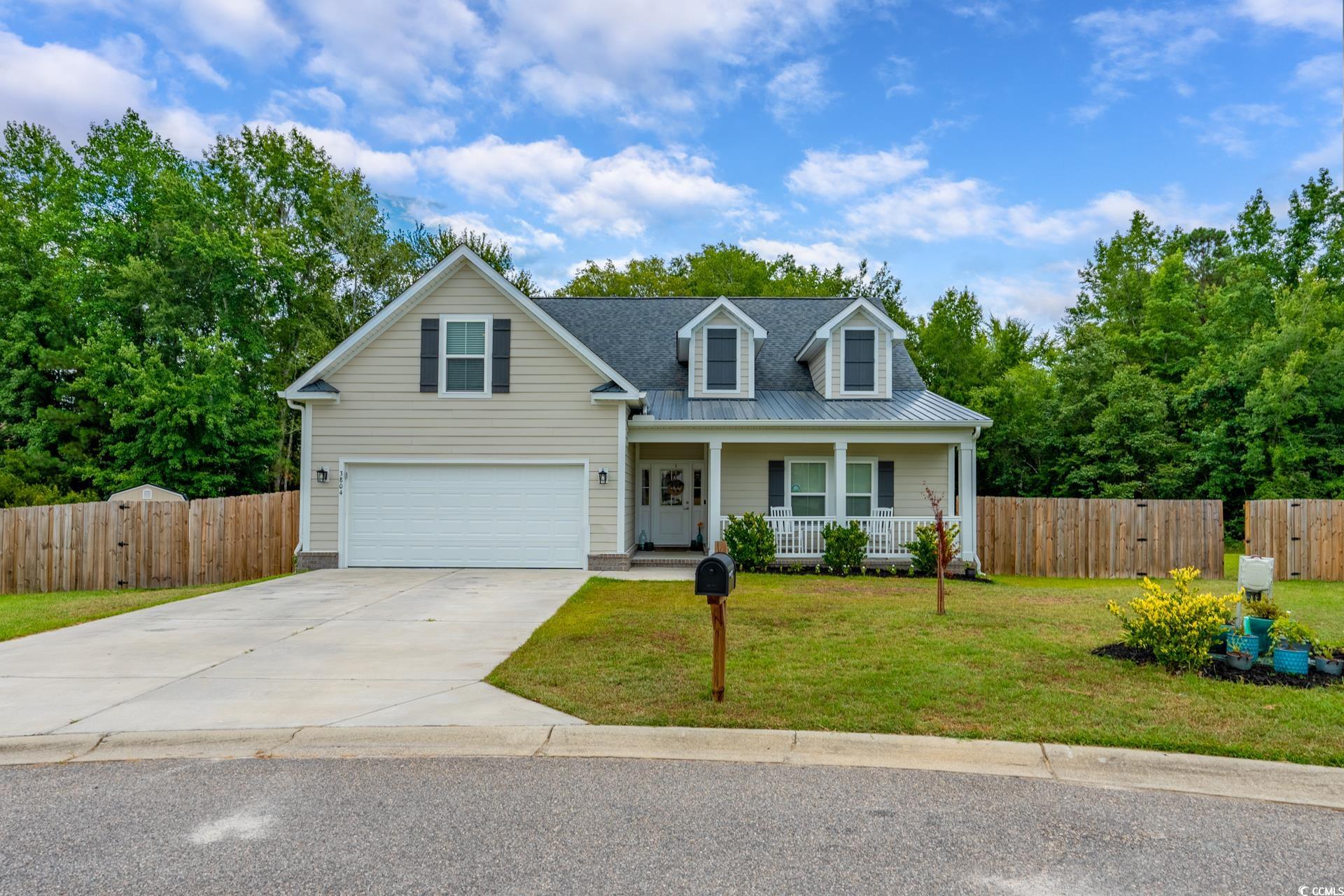 View of front of house with a porch, a garage, and