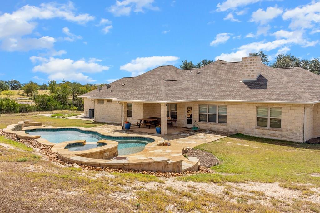 a view of a house with swimming pool and a yard