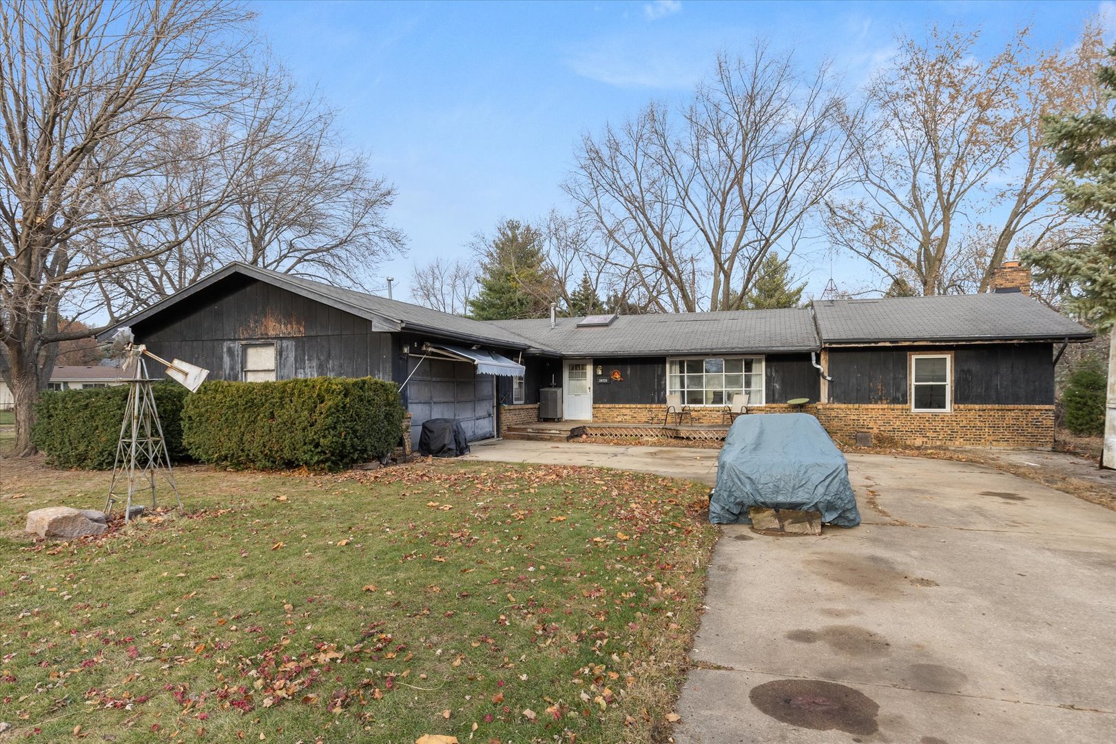 a front view of house with yard and trees in the background