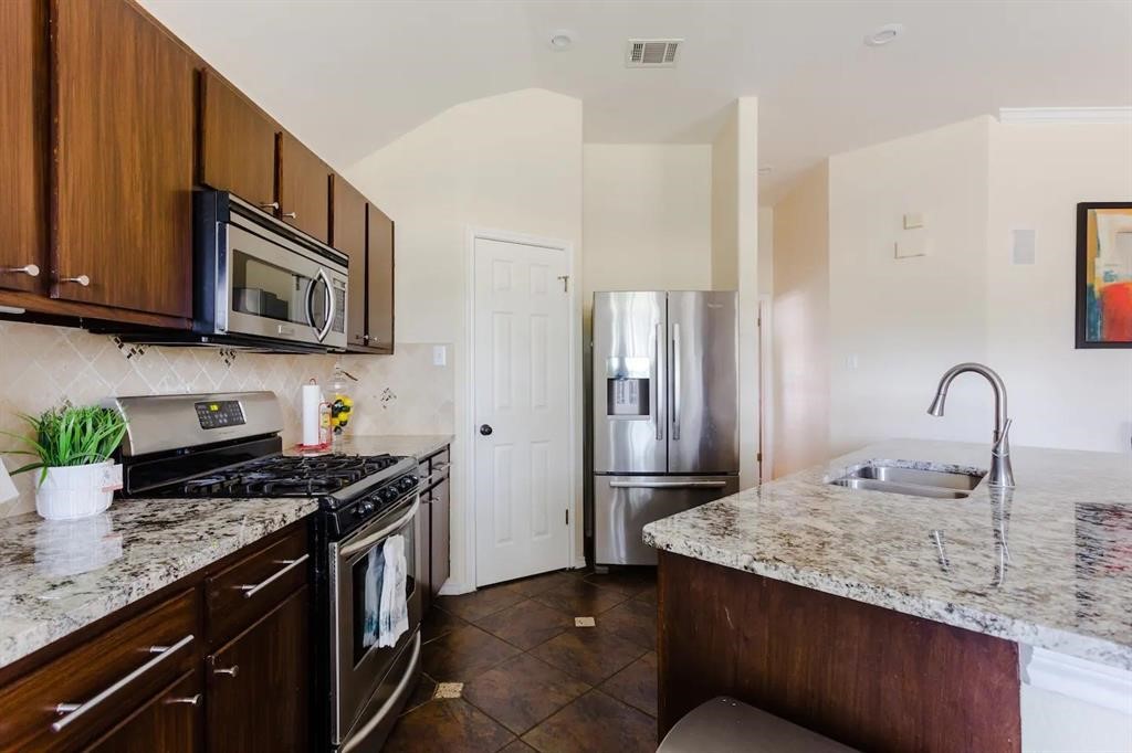 a kitchen with stainless steel appliances granite countertop a sink stove and refrigerator