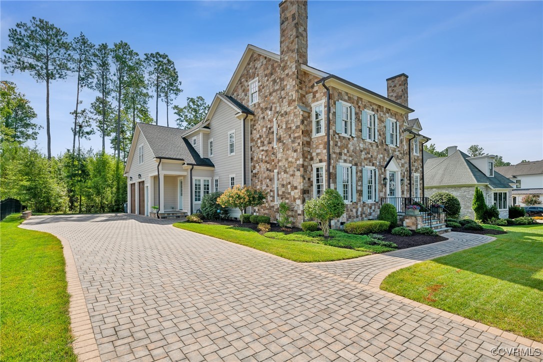 a view of a big house with a yard and plants