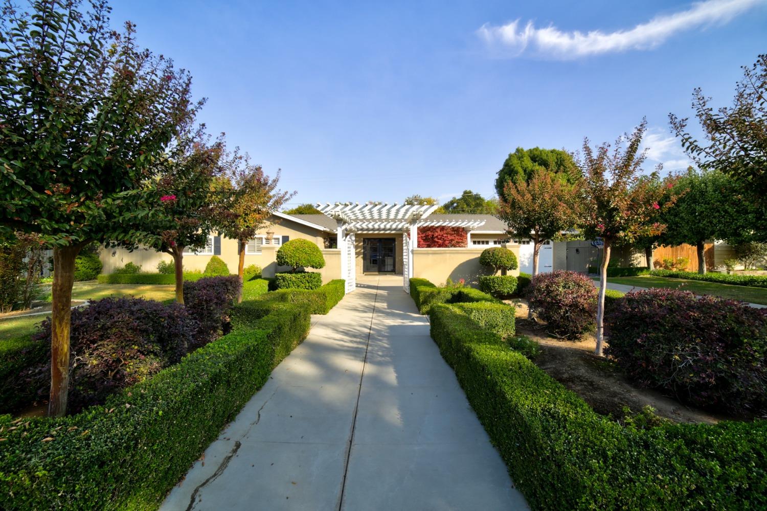 a front view of a house with a yard and potted plants