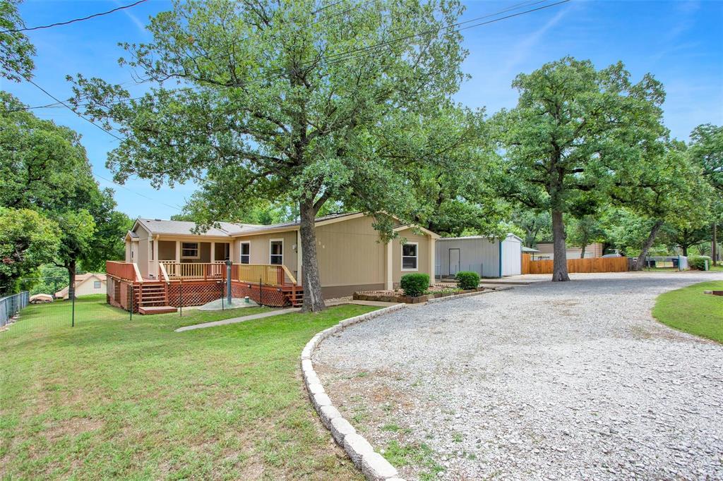 a front view of a house with a yard and trees