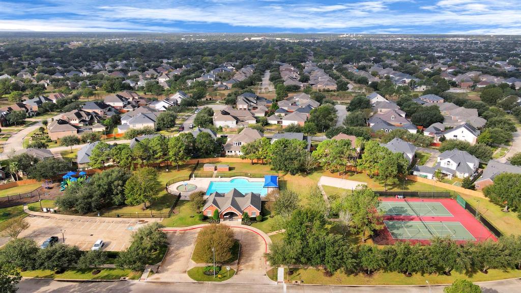 an aerial view of residential houses with outdoor space and parking