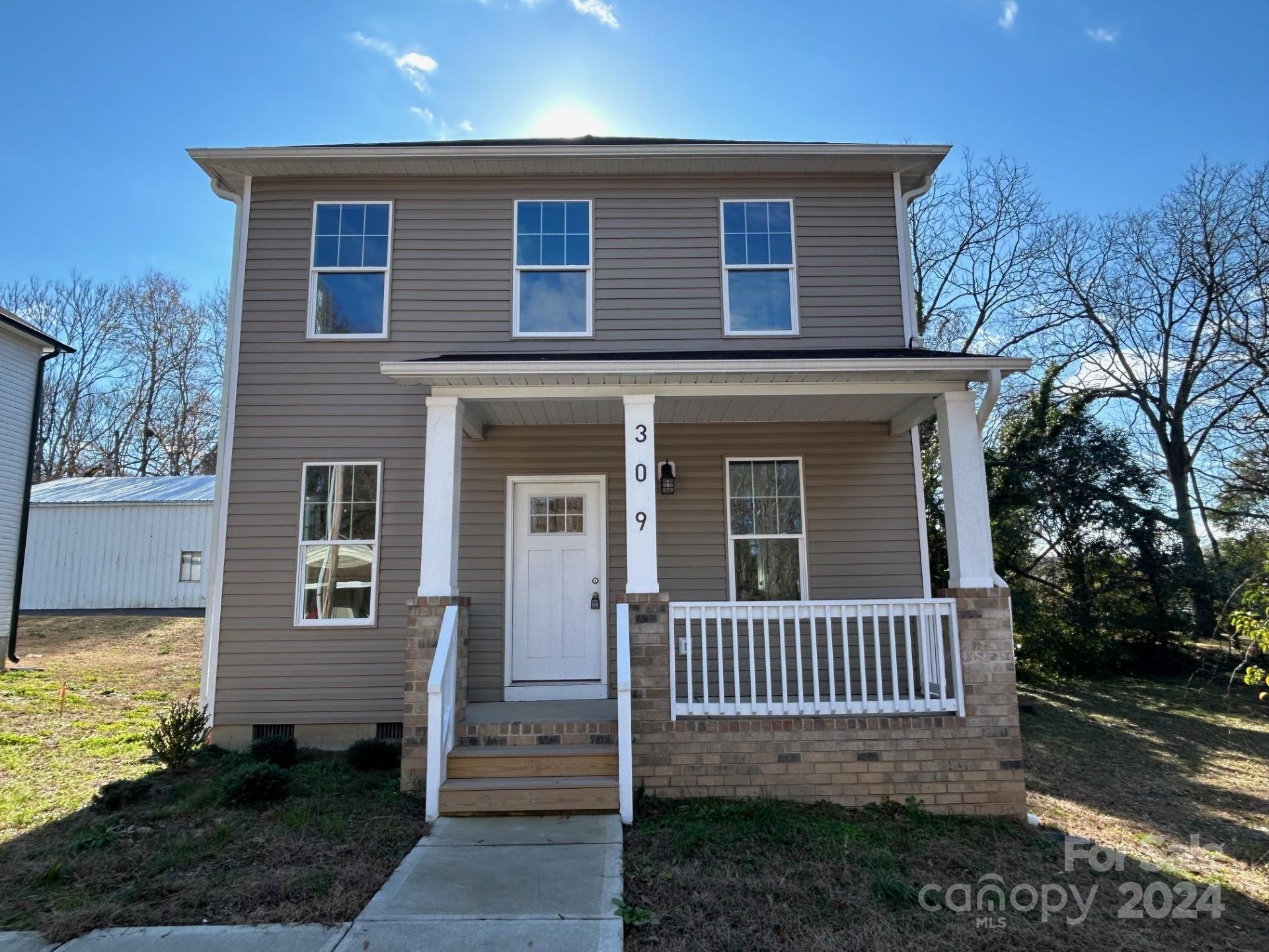 a view of a house with a porch and a yard