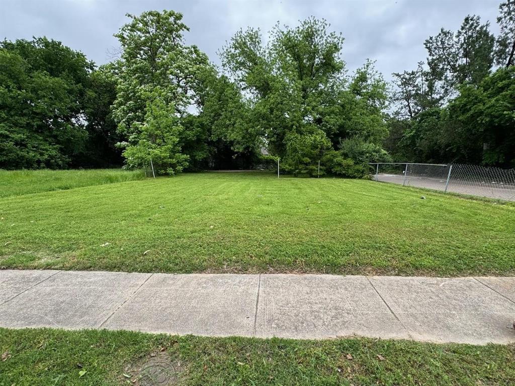 a view of a field of grass and trees