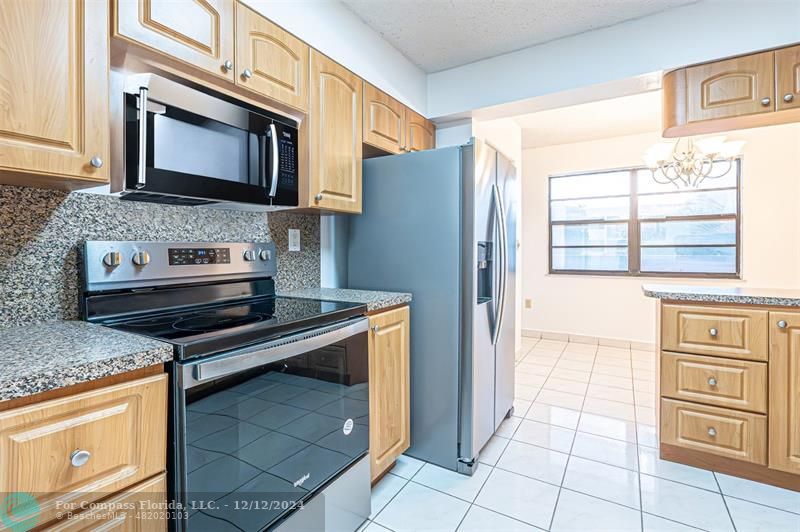 a kitchen with stainless steel appliances granite countertop a stove microwave and refrigerator