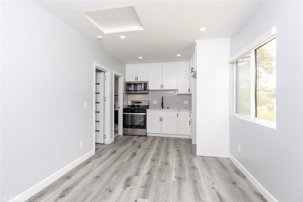 a kitchen with stainless steel appliances a refrigerator and wooden floor