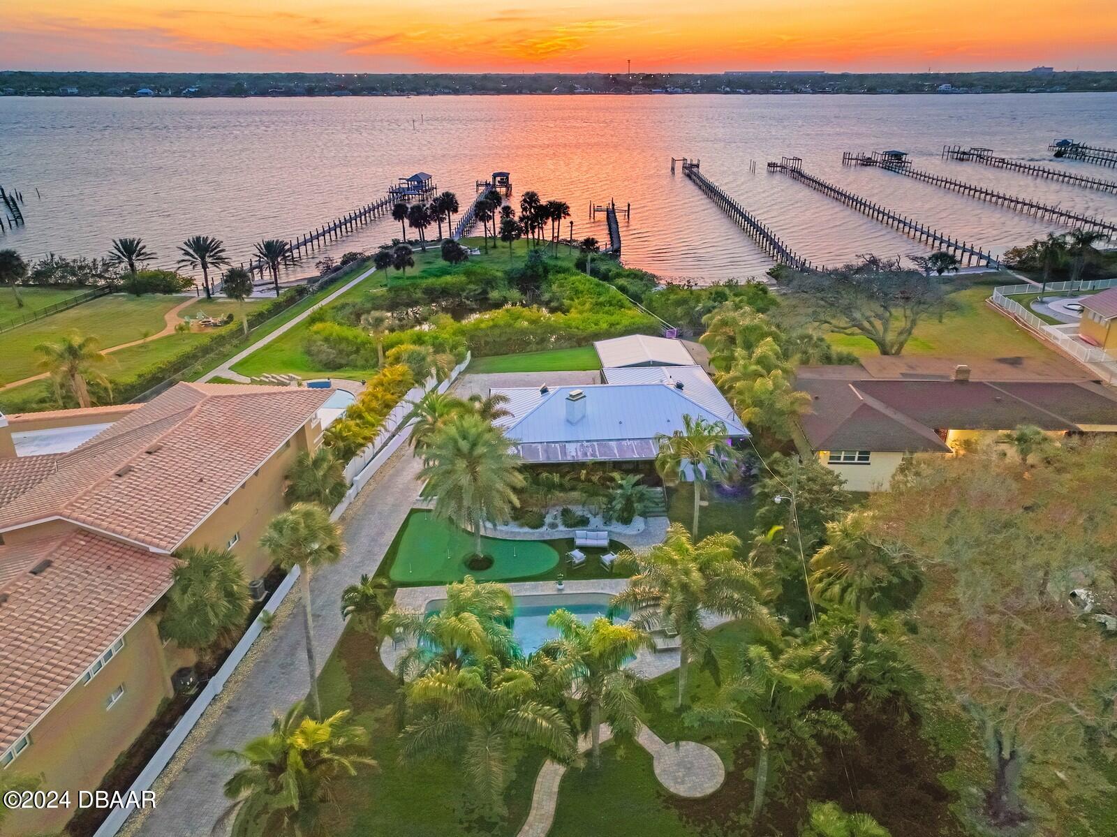 an aerial view of a house with a swimming pool and outdoor seating