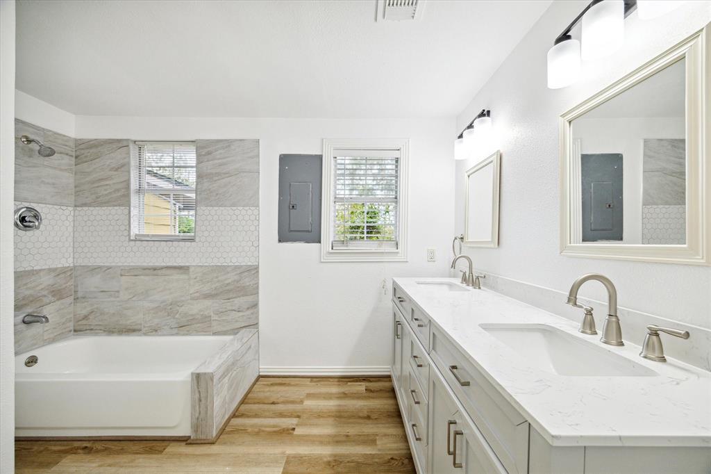 a bathroom with a tub sink and mirror