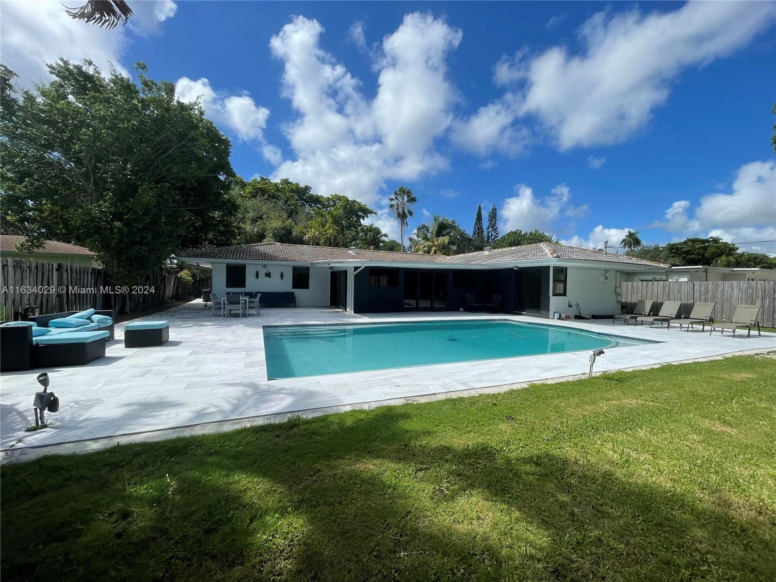 a view of house with swimming pool yard and seating area