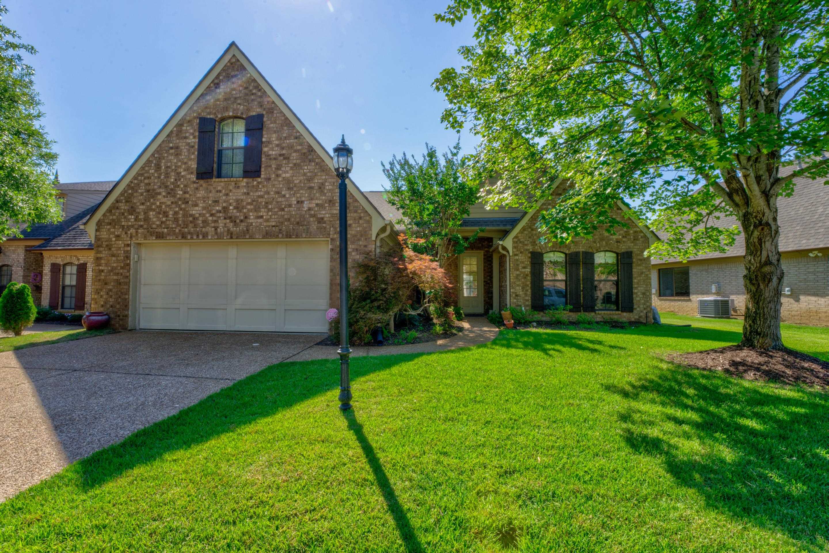 a front view of a house with a yard and trees