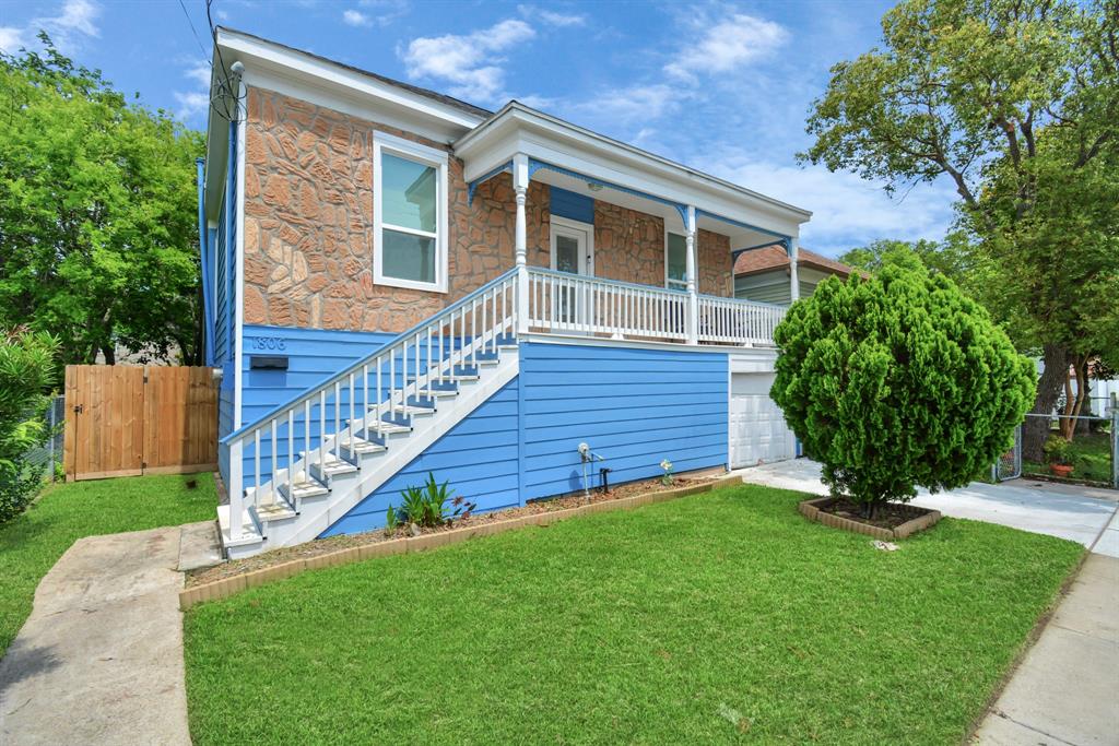 a view of a house with brick walls and a small yard with wooden fence