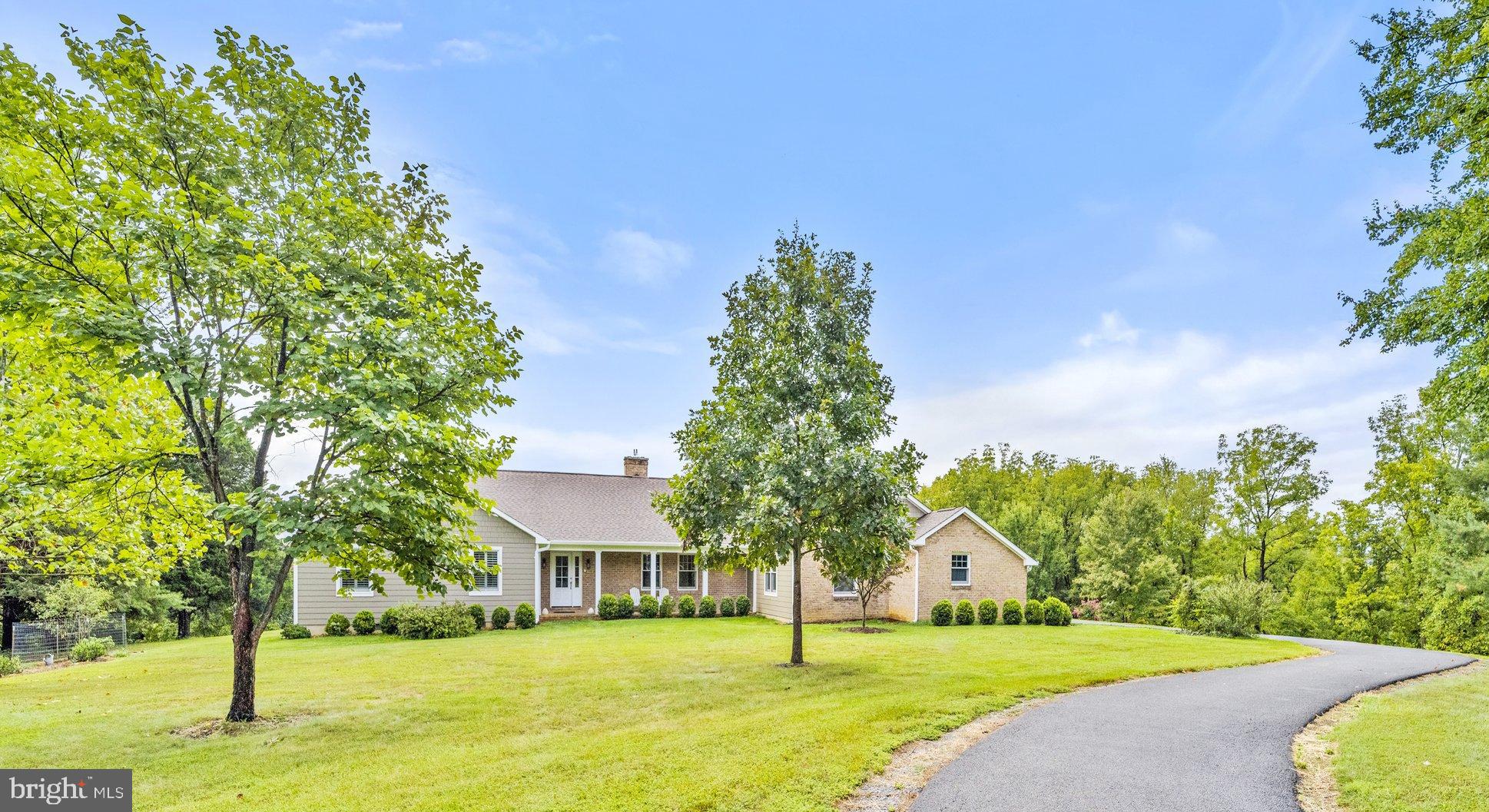 a view of a house with a big yard and large trees