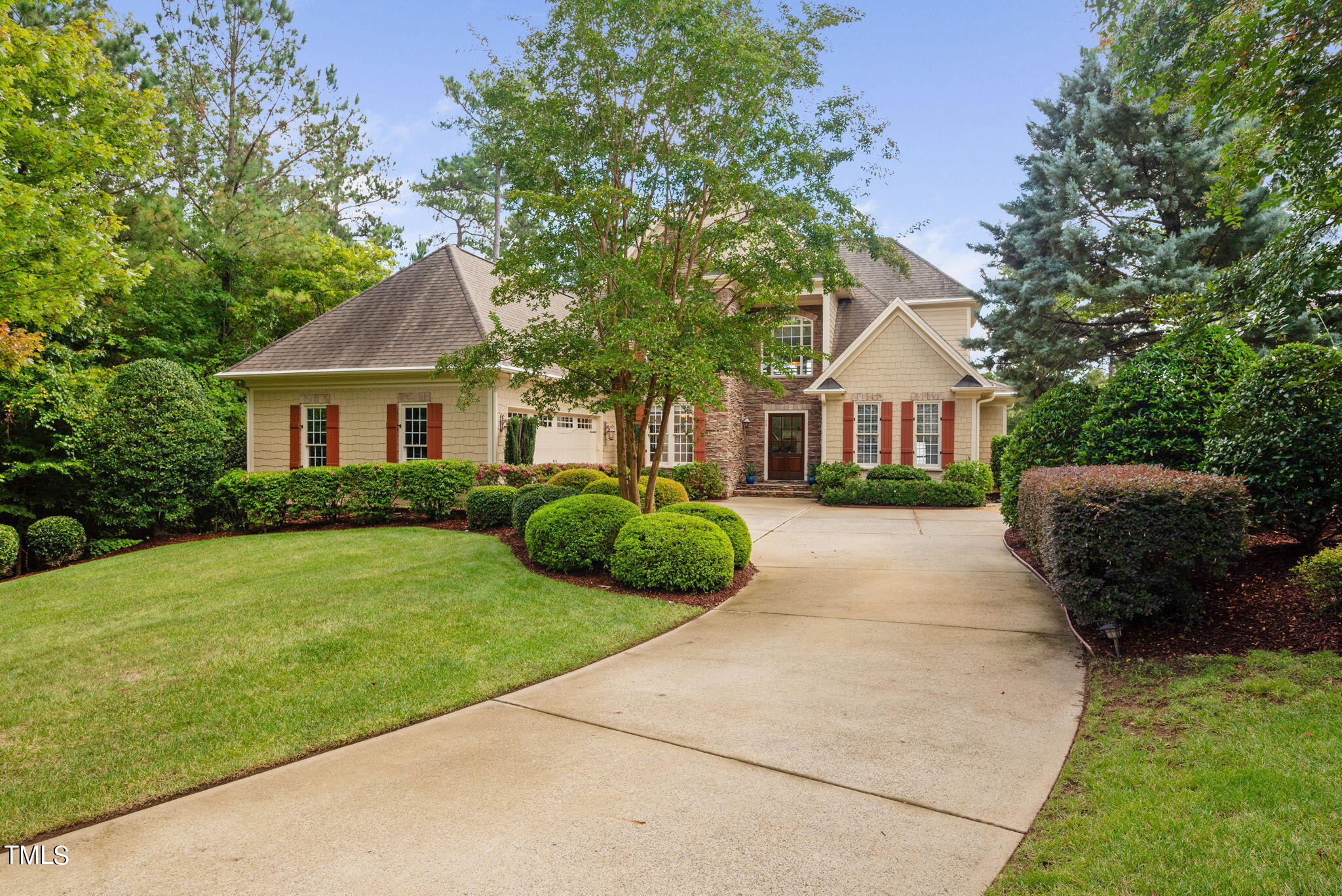 a front view of a house with a garden and yard