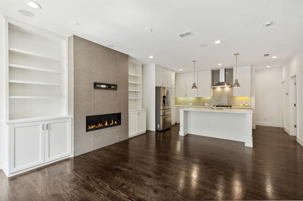 a view of kitchen with kitchen island wooden cabinets and refrigerator