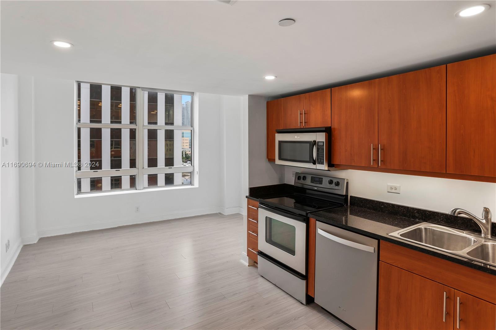 a kitchen with granite countertop stainless steel appliances a stove sink and microwave