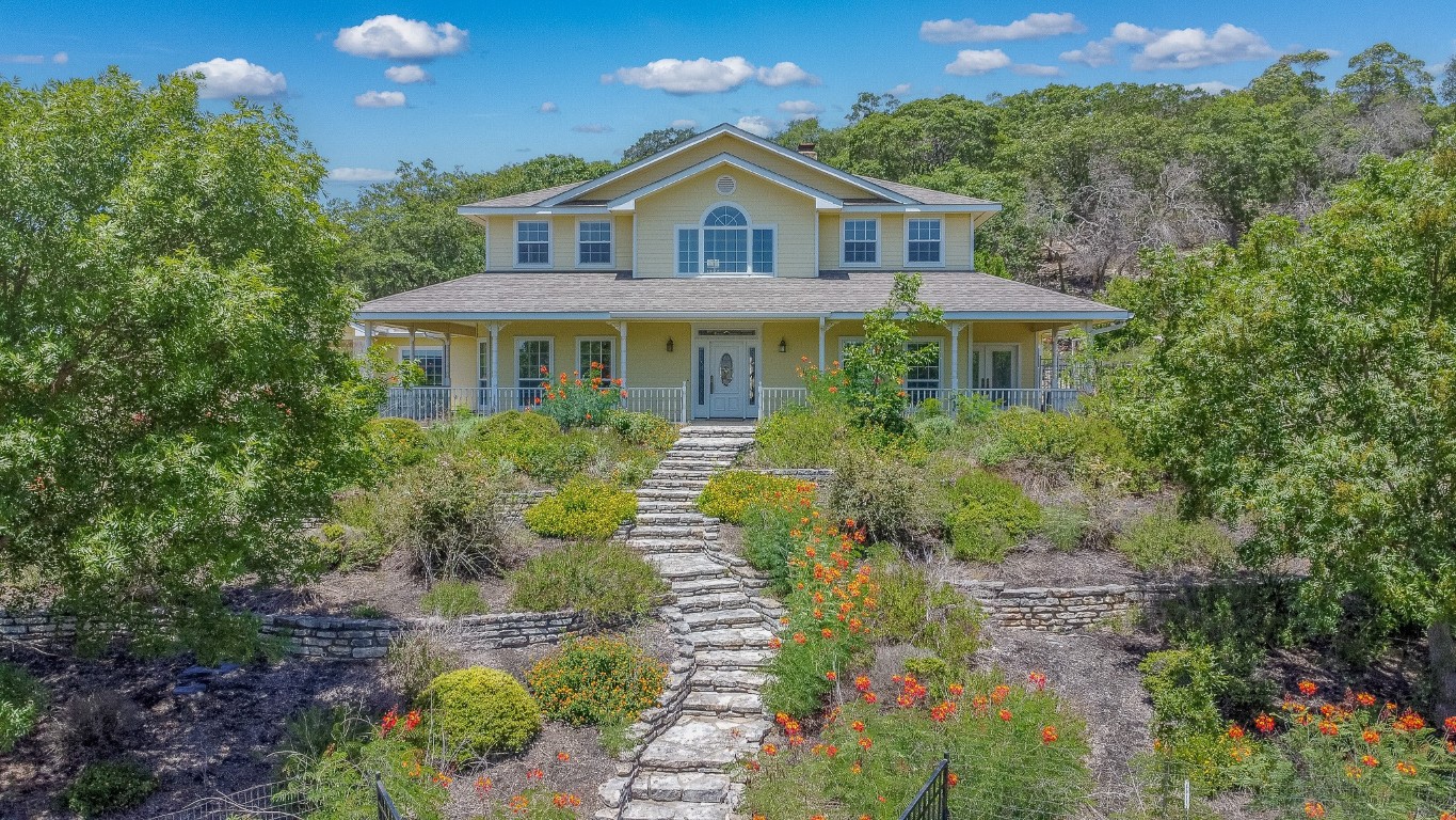 a front view of a house with a yard and fountain