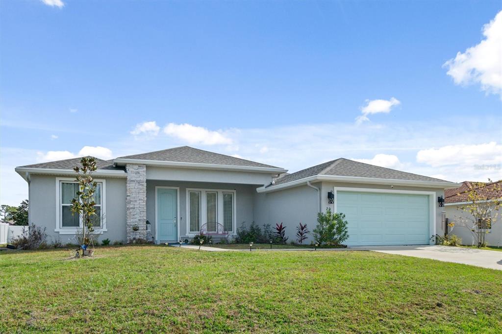 a front view of a house with a garden and yard