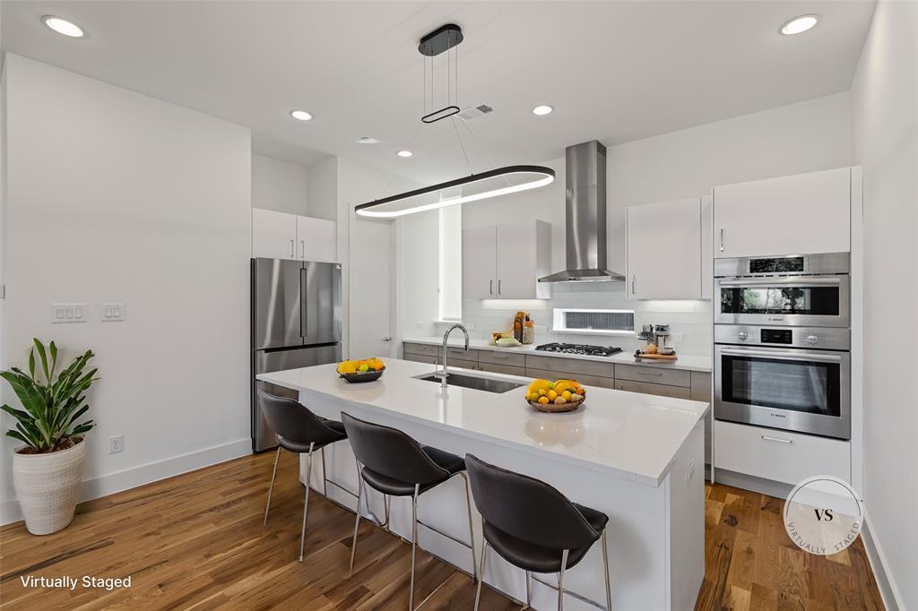 a kitchen with a sink a stove and chairs