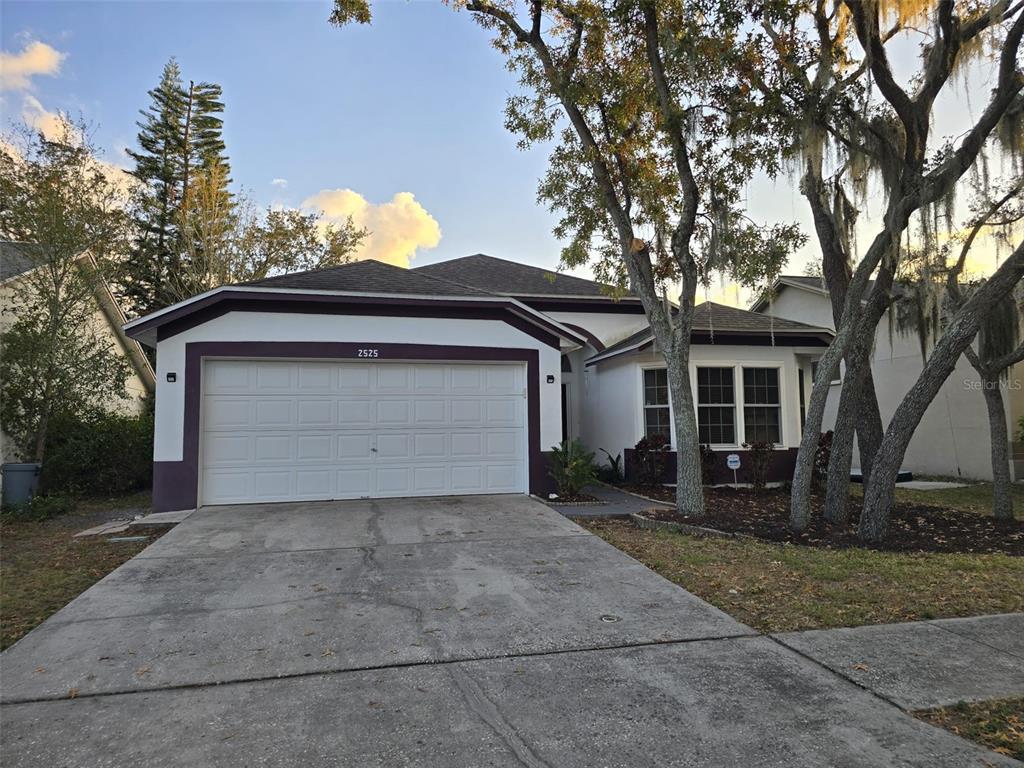 a front view of a house with a garden and trees