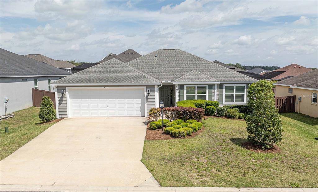 a front view of a house with a yard and plants