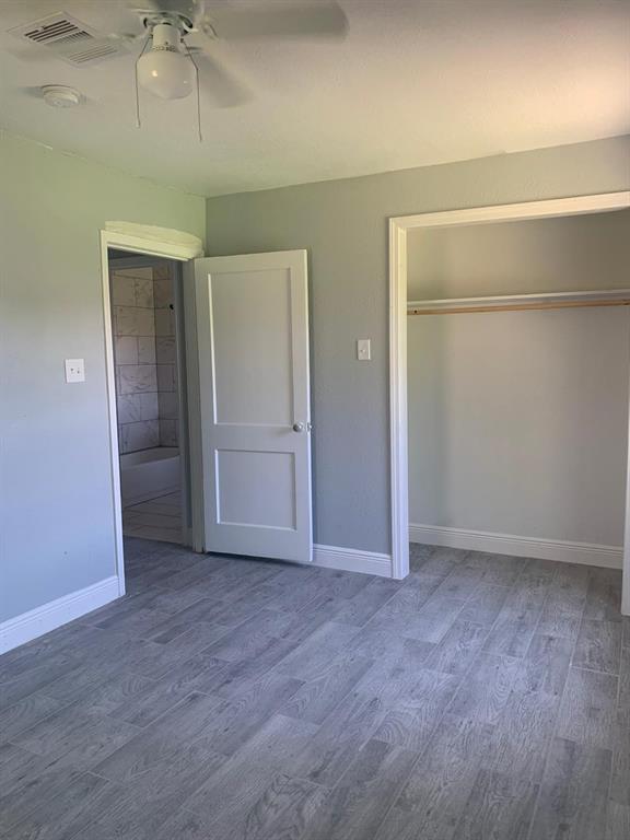 an empty room with wooden floor and closet area