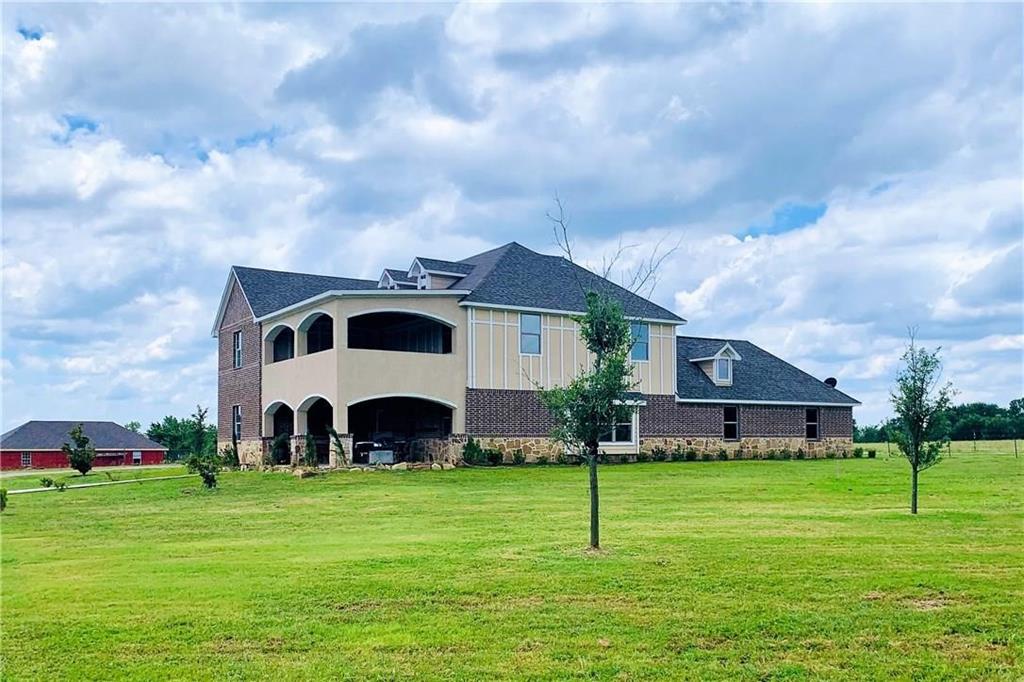 a large house with a big yard and large trees