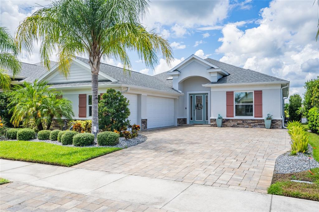 a view of a house with a yard and palm trees