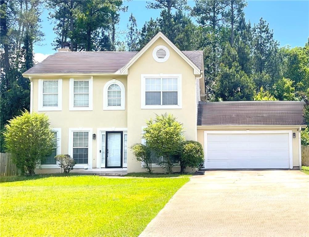 a front view of a house with a yard and trees