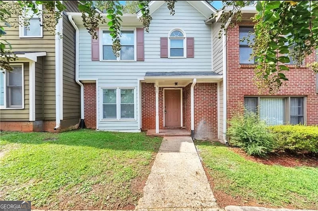 front view of a brick house with a yard