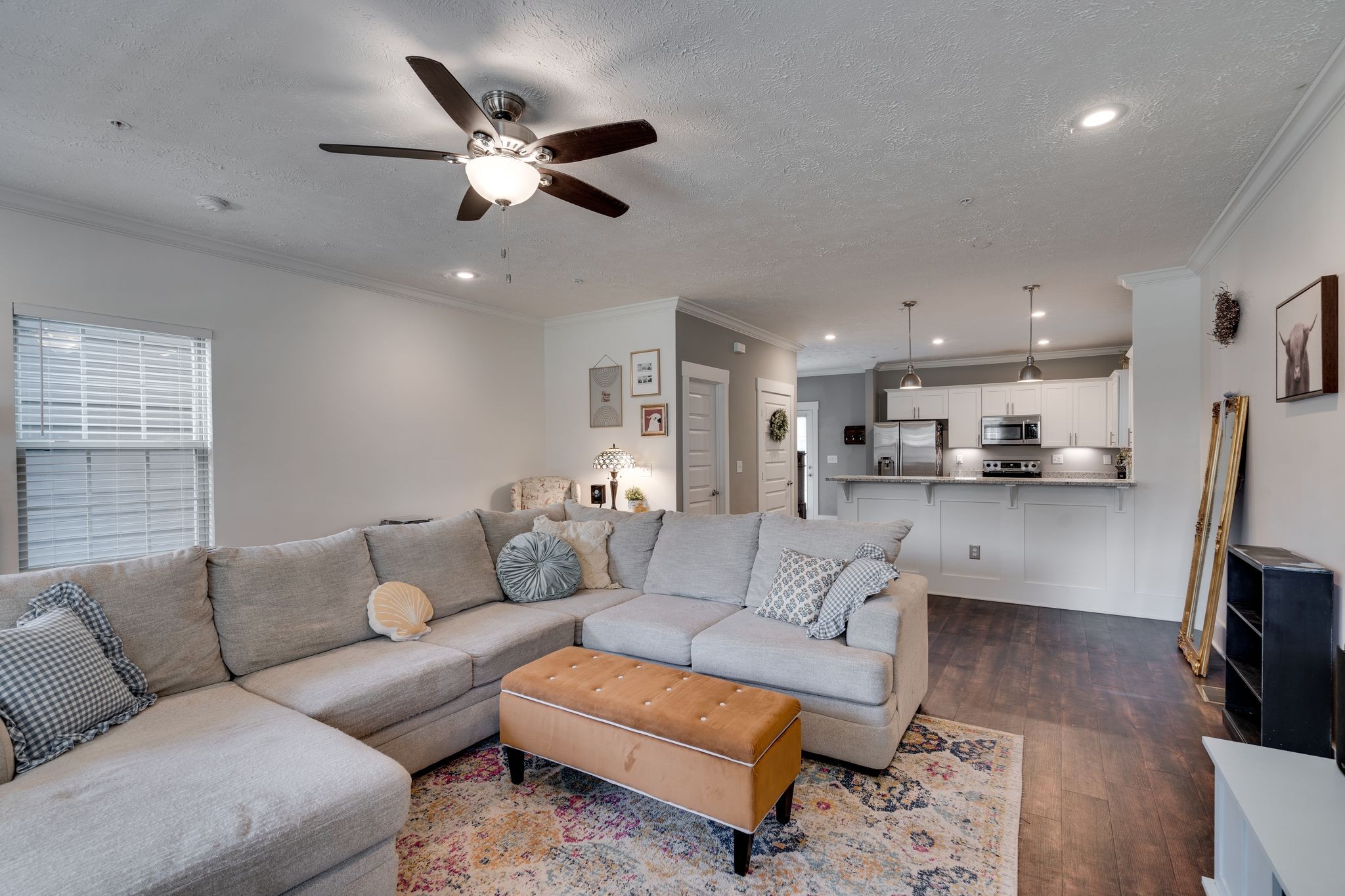 a living room with furniture kitchen view and a chandelier