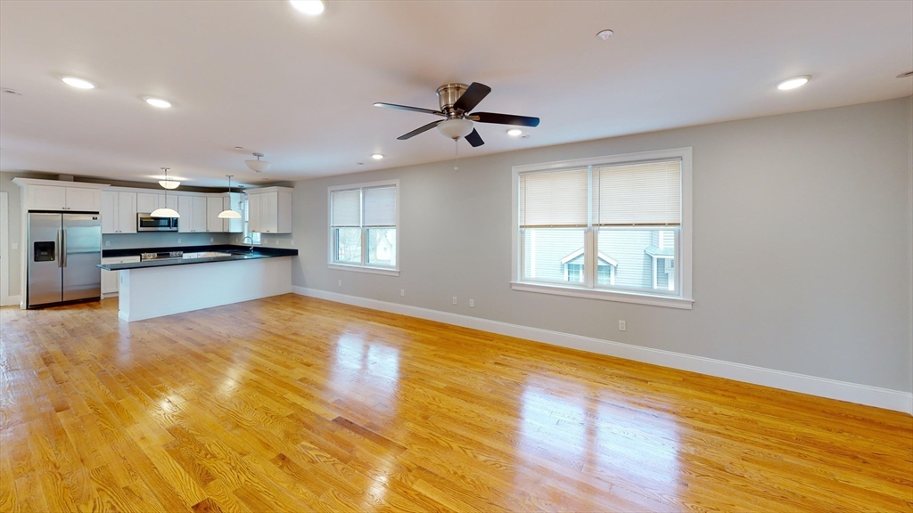 a large kitchen with stainless steel appliances granite countertop a stove and a large window