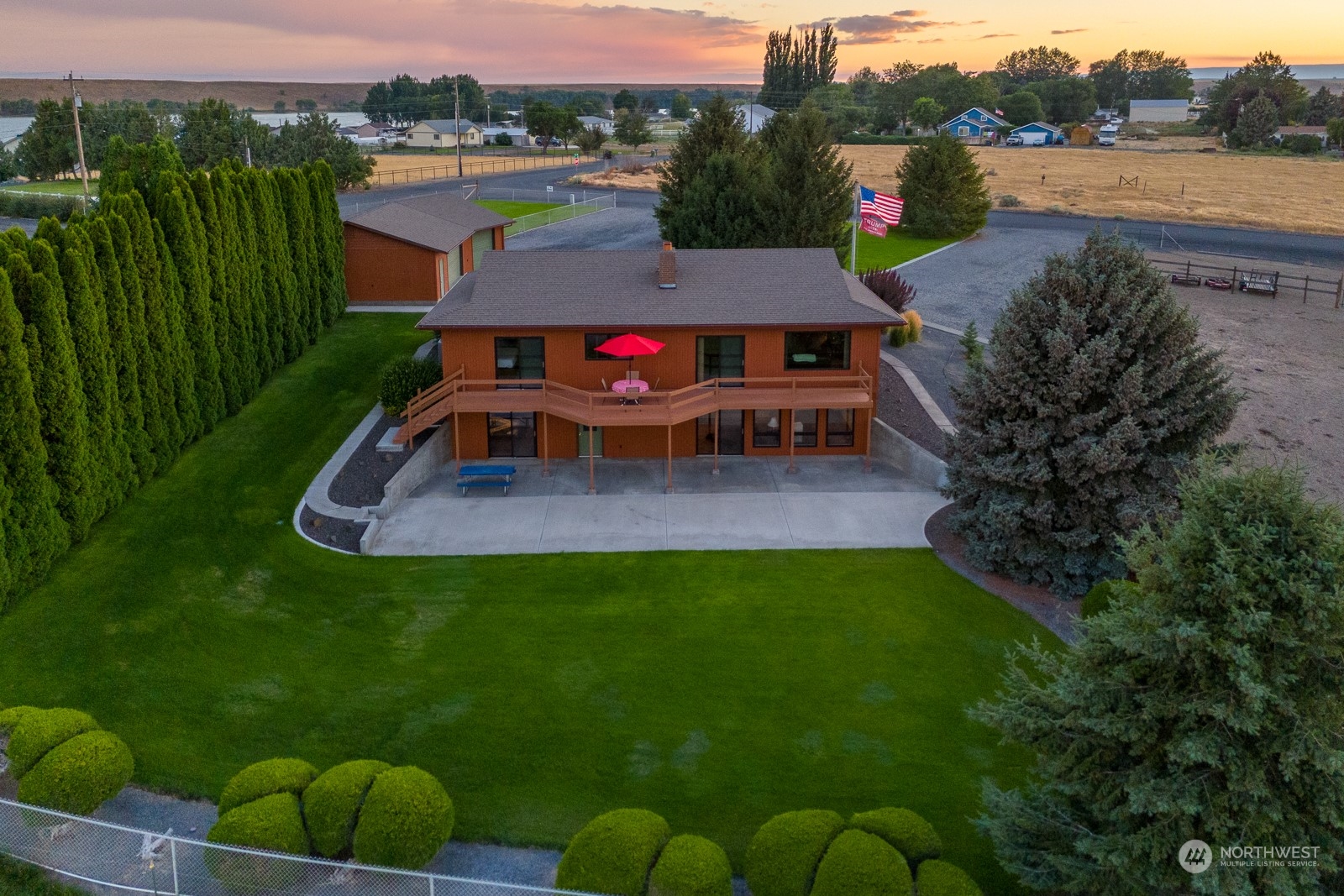 an aerial view of a house with backyard outdoor seating and city view