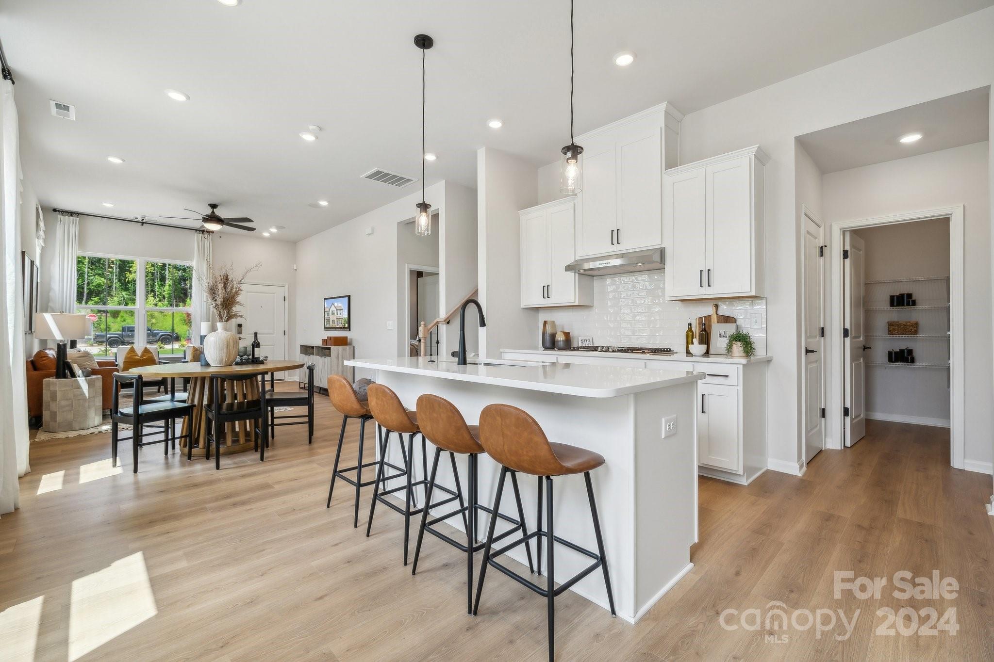 a kitchen with stainless steel appliances granite countertop sink refrigerator dining table and chairs